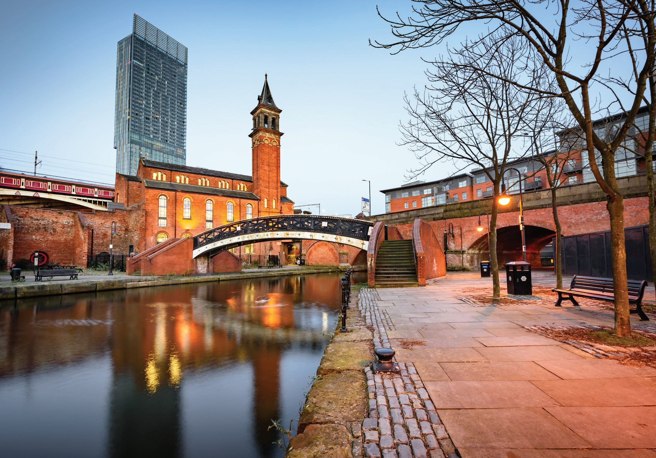 Manchester's Castlefield canal basin at dusk with the city skyline