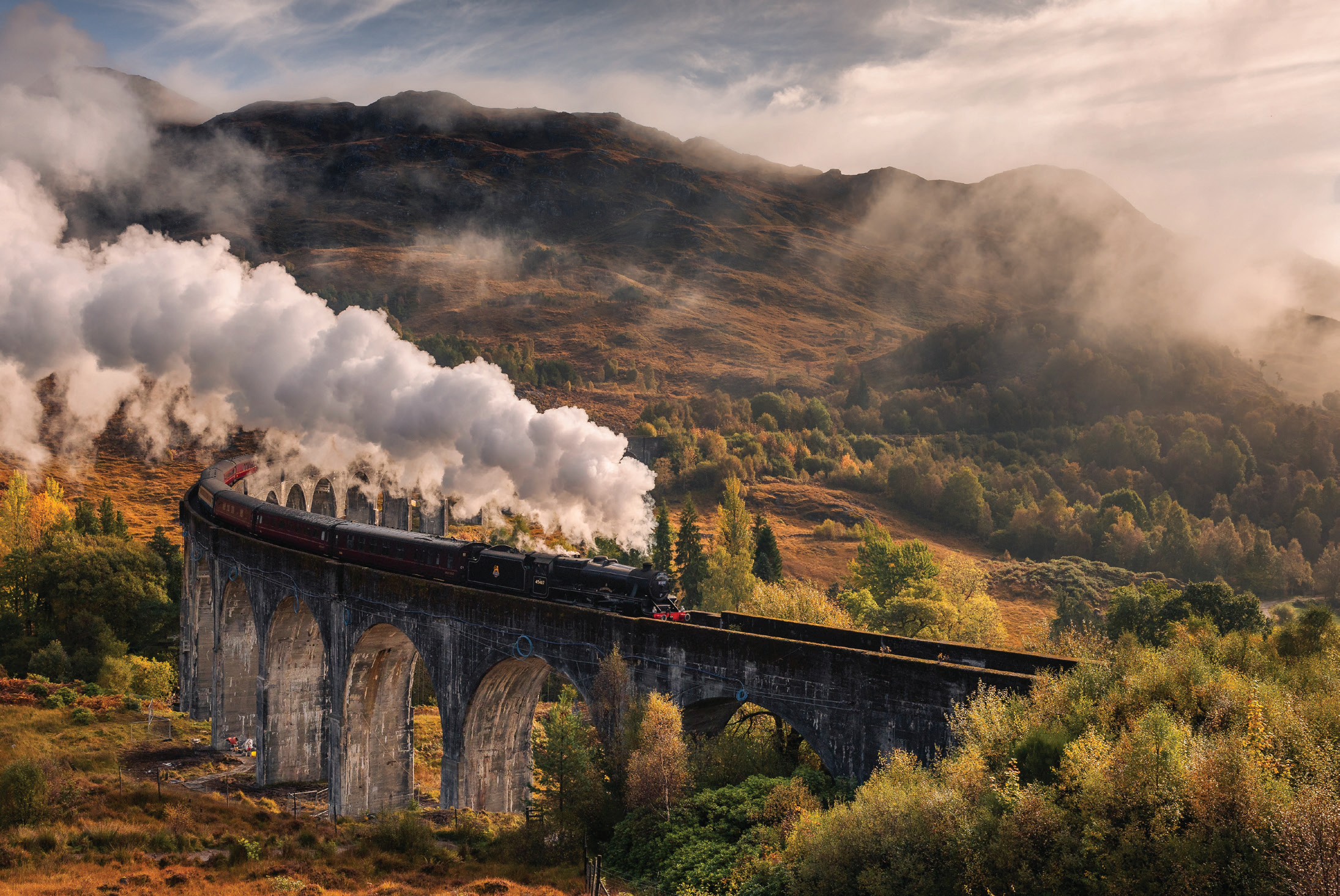 Steam train crossing the Glenfinnan Viaduct in the Scottish Highlands