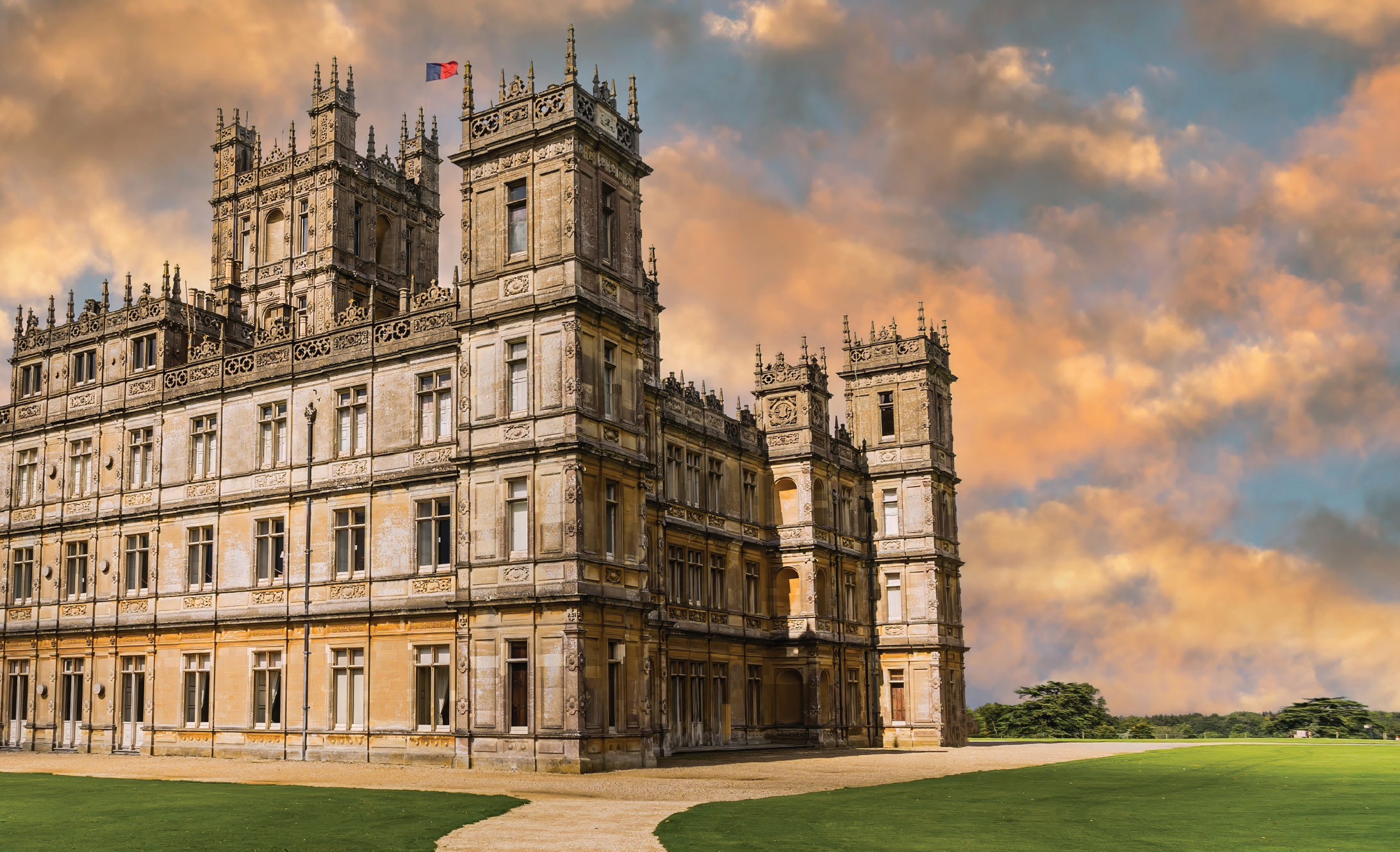 Grand English manor house beneath a dramatic evening sky